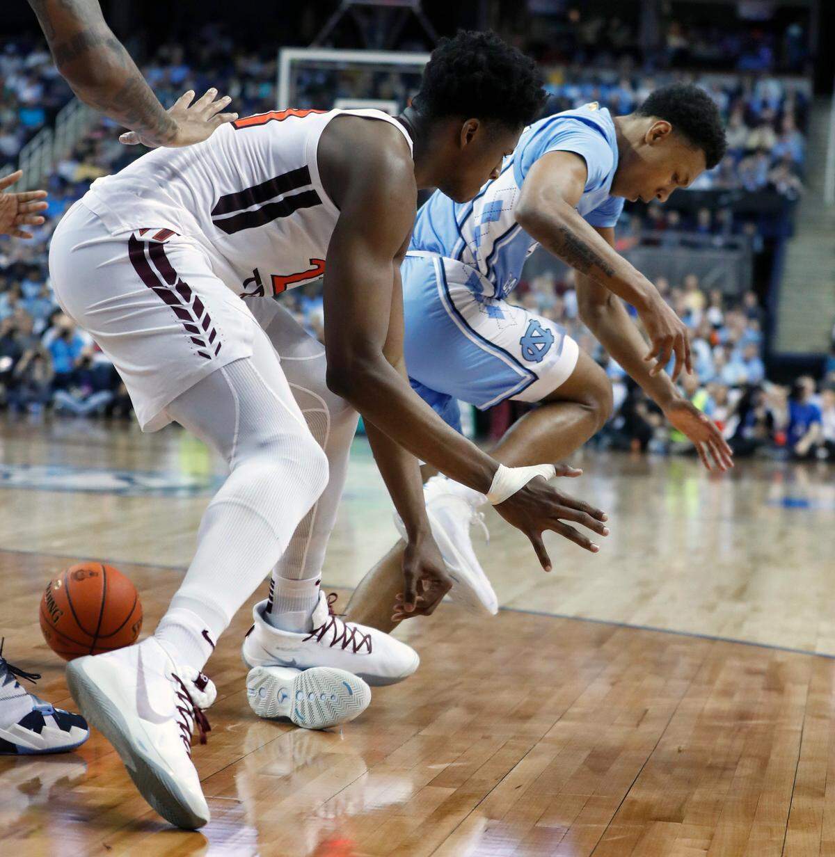 Virginia Tech’s John Ojiako (21) steps on the foot of UNC’s Christian Keeling (55) during the first half of North Carolina Tar Heels’ game against the Virginia Tech Hokies in the first round of the ACC Tournament at Greensboro Coliseum in Greensboro, N.C., Tuesday, March 10, 2020. Keeling would leave the game after the play.
