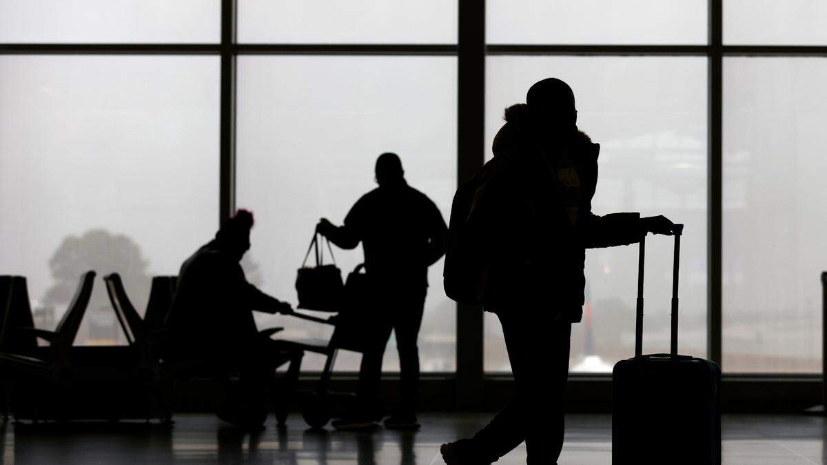 Travelers move through Terminal 2 of Raleigh-Durham International Airport as a steady rain soaks the Triangle on Thursday, Dec. 22, 2022.