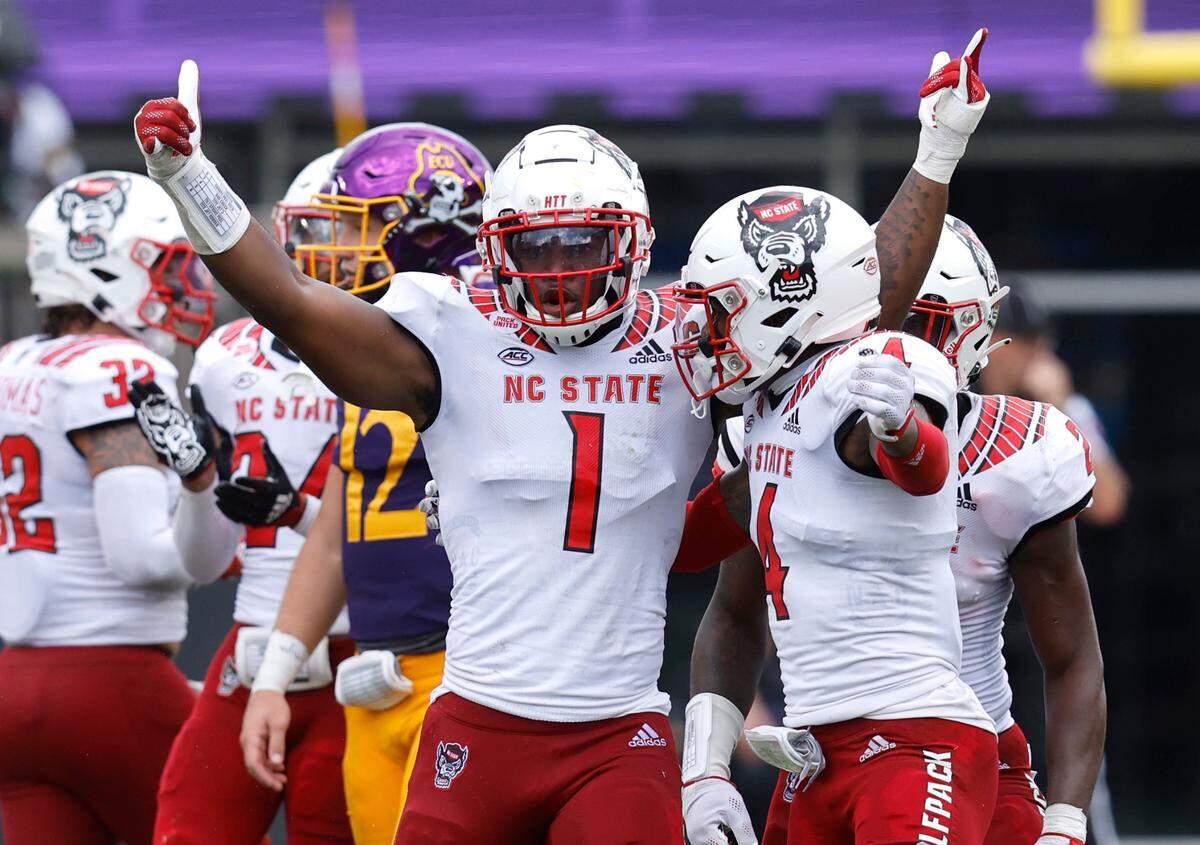 N.C. State linebacker Isaiah Moore (1) celebrates with safety Cyrus Fagan (4) after Moore made a stop during the first half of N.C. State’s game against ECU at Dowdy-Ficklen Stadium in Greenville, N.C., Saturday, Sept. 3, 2022.