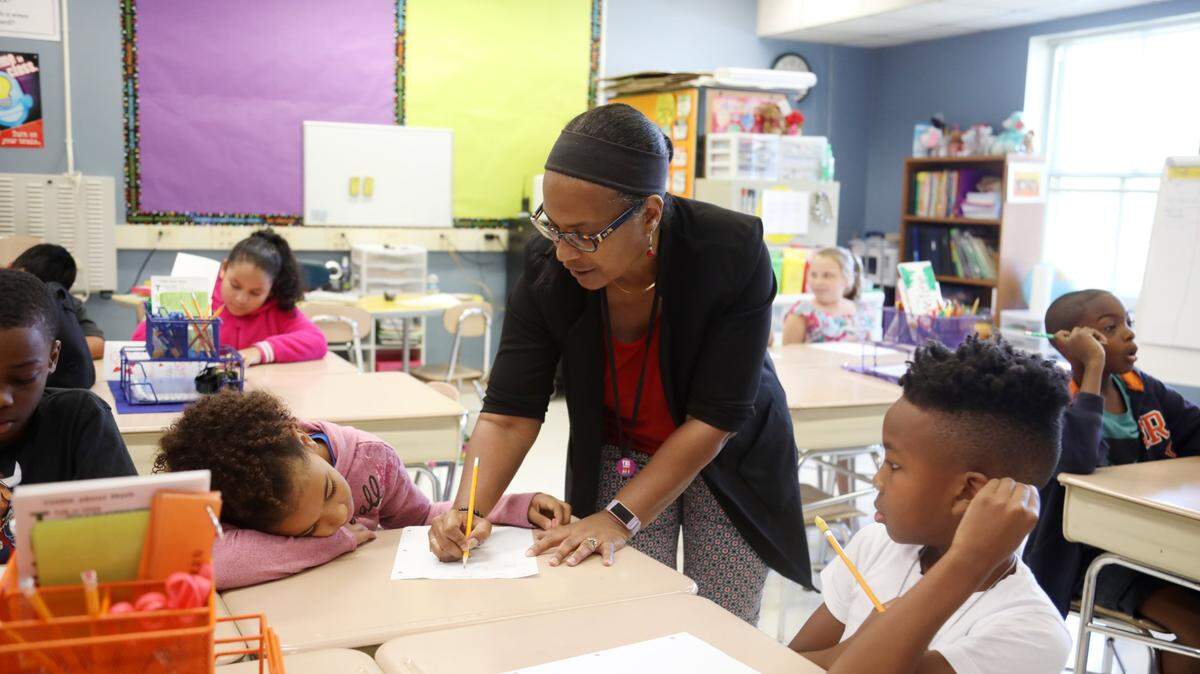 Third graders Ana Toller, left, and D’Ki Watson, right, get help on a math problem from their teacher Yvonne Gayton, center, at Fox Road Elementary School in North Raleigh on Wednesday, Sept. 11, 2019.