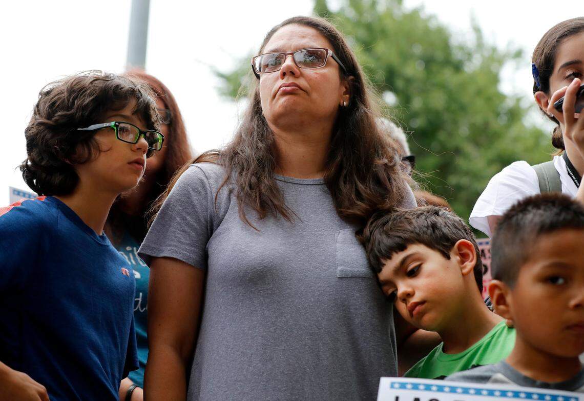 Madeline DiDonato of Holly Springs listens with her sons, Nicholas, 8, right, and Peter, 11, during a rally to stand against family separation along the southern U.S. border Tuesday, June 26, 2018. The rally, outside the federal building and courthouse in Raleigh, is part of a weekly protest, Tuesdays With Tillis.