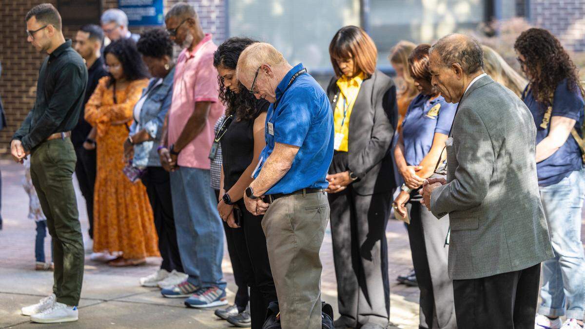 Members of the community pray Friday, Oct. 13, 2023 at the city’s municipal building during a vigil to remember five people, Nicole Connors, Susan Karnatz, Mary Marshall, James Thompson and Gabriel Jesús Torres who were killed in a mass shooting in the Hedingham neighborhood in northeast Raleigh one year ago.
