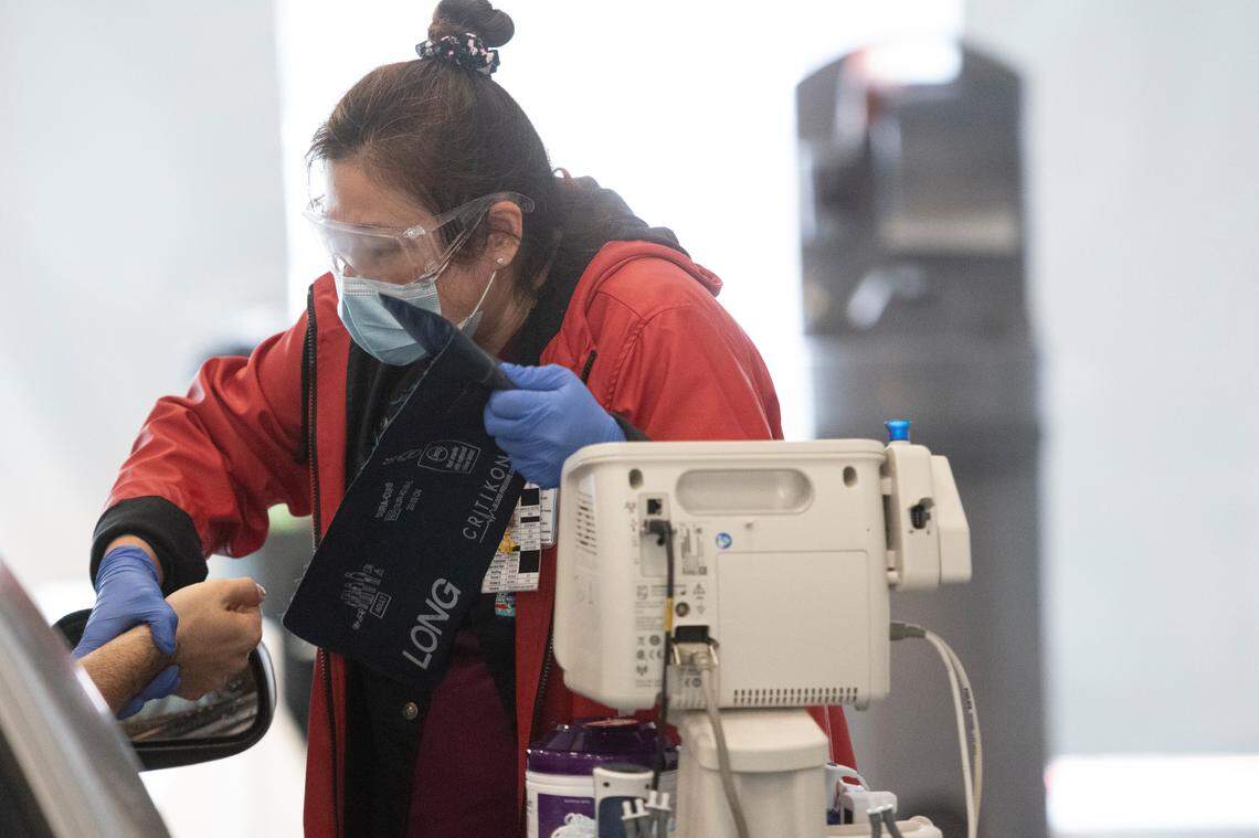 Nursing assistant Seiko Wong checks the oxygen levels, blood pressure and temperature of a patient arriving at the Emergency Department at UNC Hospital in Chapel Hill Monday, June 16, 2020. UNC staff works under a large drive-through outdoor tent while triaging patients arriving at the ED.