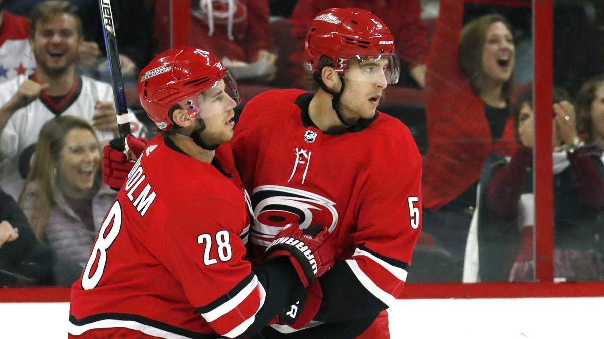 The Canes' Noah Hanifin (5) celebrates his goal with Elias Lindholm (28) during the second period of a preseason NHL game played between the Carolina Hurricanes and the Washington Capitals at PNC Arena in Raleigh, N.C., on Sept. 29, 2017.