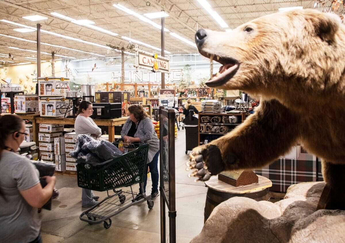 Black Friday shoppers walk through Bass Pro Shops in Cary, N.C. with full carts before 6 a.m. on Nov. 26, 2021. For many major retailers, deals started online for the season’s hottest gifts long before Thanksgiving arrived. But many shoppers still enjoy getting to stores early the day after Thanksgiving.