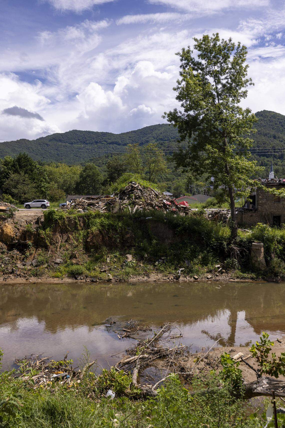 Debris and rubble litter the riverbanks along the Swannanoa River and U.S. 70 in the unincorporated mountain community of Swannanoa on Aug. 13. 