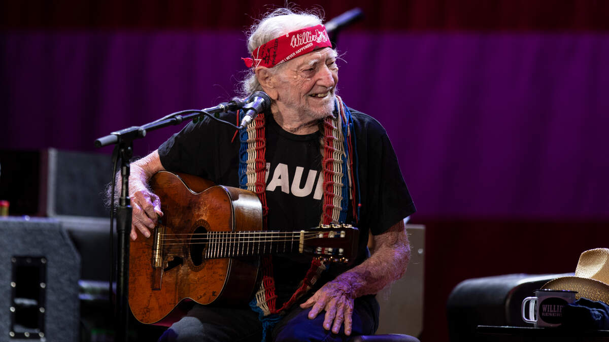 Willie Nelson grins at harmonica player Mickey Raphael on their Outlaw Music Festival tour stop at Raleigh, N.C.’s Coastal Credit Union Music Park, Saturday night, Sept. 8, 2023.