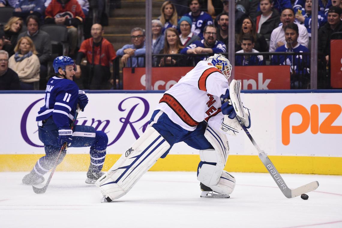 Carolina Hurricanes emergency goalie David Ayres, right, comes out of his net to play the puck against the Toronto Maple Leafs during second-period NHL hockey action in Toronto, Saturday, Feb. 22, 2020. Ayres, who serves as the Toronto Marlies’ ice resurfacer driver, replaced Petr Mrazek in-net after a delay in action.