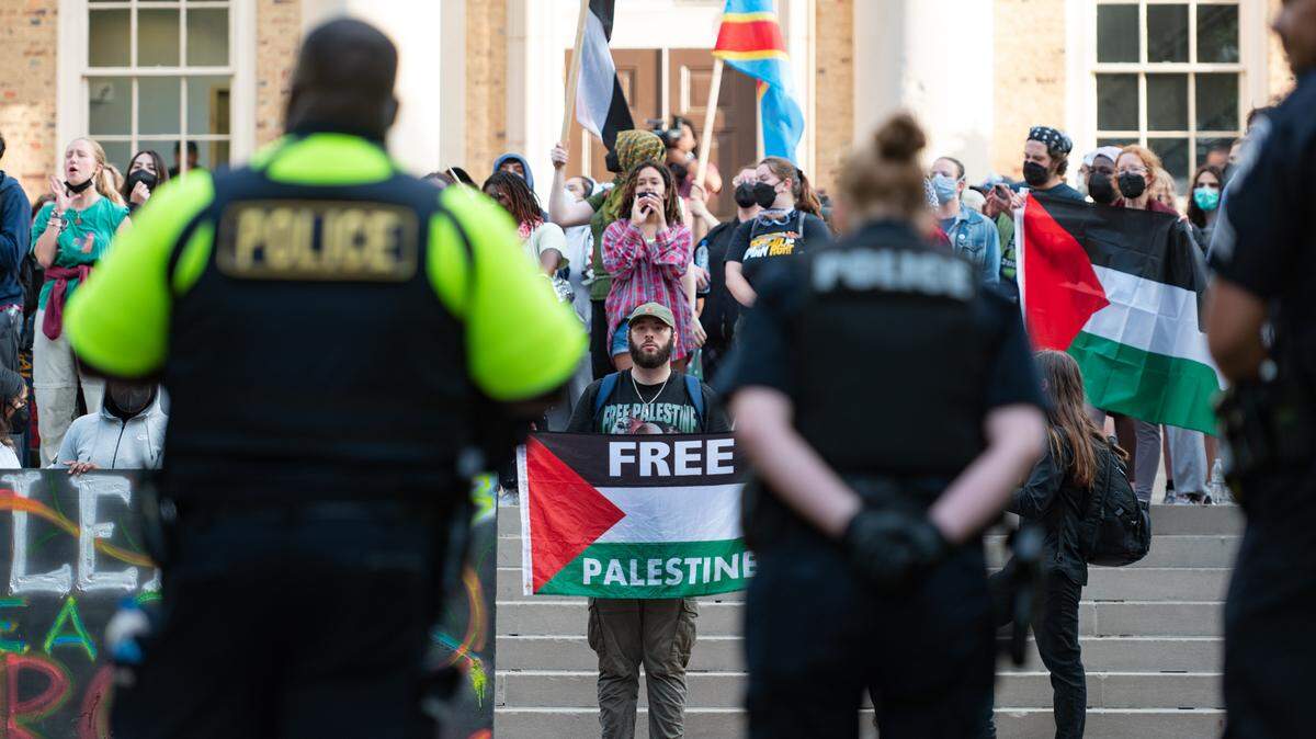 A line of police face a group of protesters outside of South Building on the morning of Tuesday, April 30. Arrests had been made at a pro-Palestinian encampment earlier that morning.