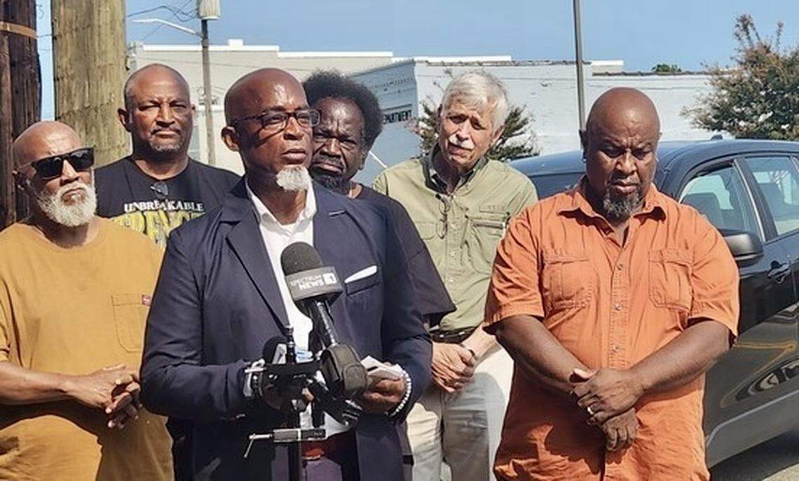 Dwayne Hicks stands before a microphone in front of Littleton Town Hall during a Monday, Sept, 9, 2024 press conference. He, his attorney and Granville County NAACP members said town officials should investigate part-time officer Mark Oakley.