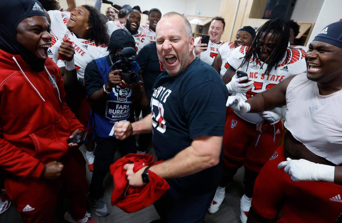 N.C. State head coach Dave Doeren celebrates in the locker room after N.C. State’s 30-27 overtime victory over UNC at Kenan Stadium in Chapel Hill, N.C., Friday, Nov. 25, 2022.