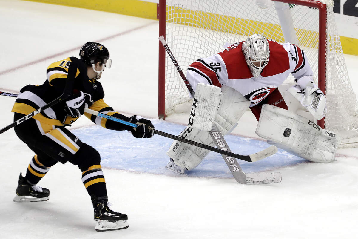 Pittsburgh Penguins’ Jared McCann (19) can’t get his stick on a rebound in front of Carolina Hurricanes goaltender Curtis McElhinney (35) during the first period of an NHL hockey game in Pittsburgh, Sunday, March 31, 2019. (AP Photo/Gene J. Puskar)