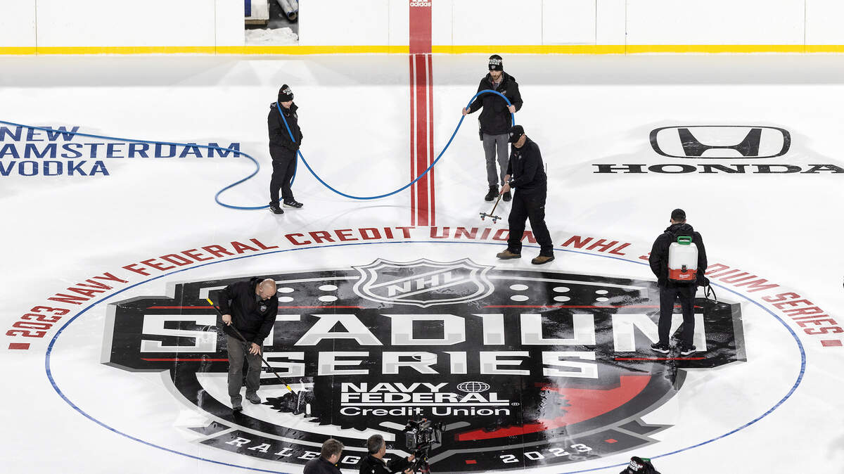 A crew works to install a logo as preparations continue for the Carolina Hurricanes’ Stadium Series game against the Washington Capitals on Monday, Feb. 13, 2023, at Carter-Finley Stadium in Raleigh, N.C.