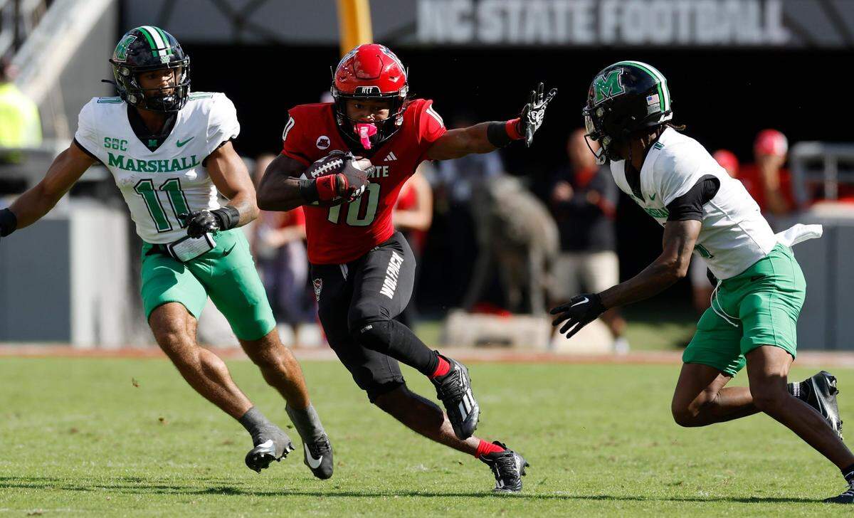 N.C. State wide receiver KC Concepcion (10) looks to fend off Marshall defensive back Josh Moten (1) during the first half of N.C. State’s game against Marshall at Carter-Finley Stadium in Raleigh, N.C., Saturday, Oct. 7, 2023.
