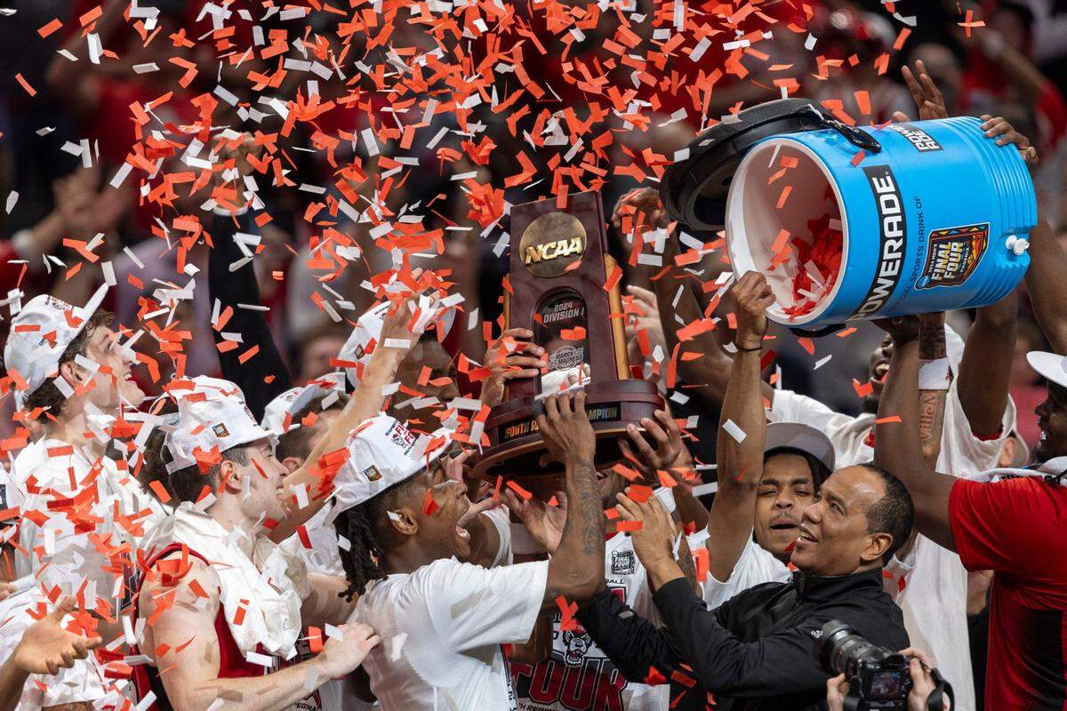 N.C. State coach Kevin Keatts and his players accept the NCAA South Regional Championship trophy in a shower of confetti following the Wolfpack’s 76-64 victory over Duke on Sunday, March 31, 2024 at the American Airlines Center in Dallas, Texas.