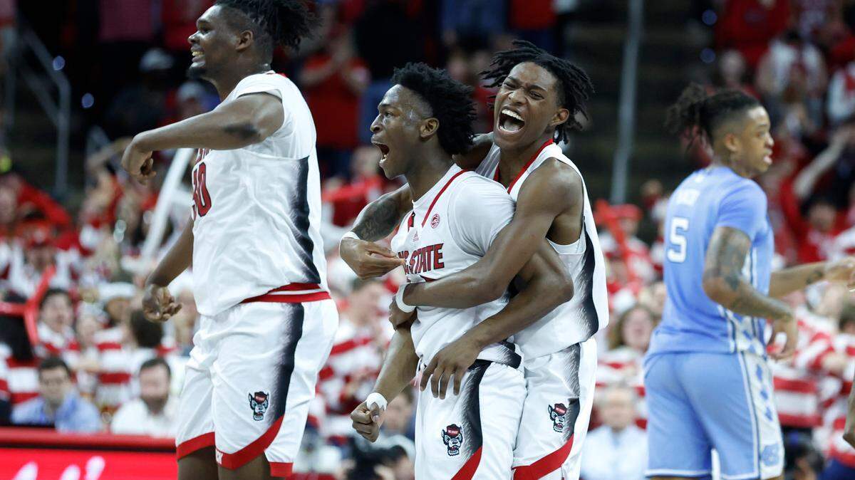N.C. State’s Terquavion Smith (0) celebrates with Jarkel Joiner (1) after Joiner hit a three-pointer to put the Wolfpack up 67-60 during the second half of N.C. State’s 77-69 victory over UNC at PNC Arena in Raleigh, N.C., Sunday, Feb. 19, 2023.