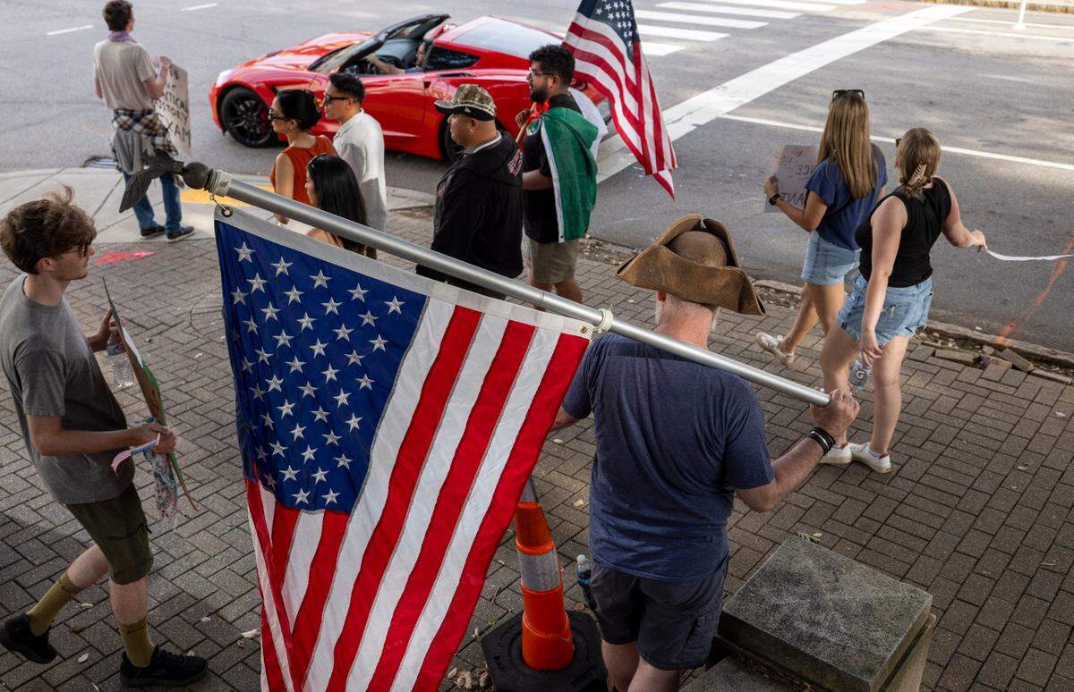Demonstrators stand at the corner of Dawson and Wilmington Streets during the ‘No Kings’ rally at the North Carolina State Capital on Saturday, June 14, 2025 in Raleigh, N.C.