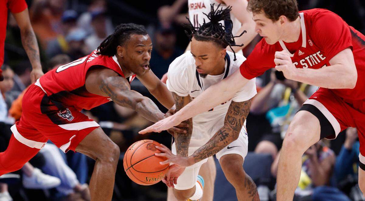 Virginia’s Dante Harris (1) tries to steal the ball from N.C. State’s DJ Horne (0) and Ben Middlebrooks (34) during the first half of N.C. State’s game against Virginia in the semifinals of the 2024 ACC Men’s Basketball Tournament at Capital One Arena in Washington, D.C., Friday, March 15, 2024.