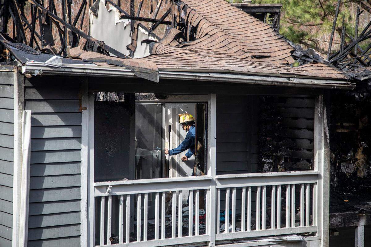 An investigator with the Cary Fire Department works at the scene of a three-story apartment fire on Harlon Drive at the Aurella Cary apartments Tuesday, March 8, 2022. The Monday afternoon fire killed a child and left three people hospitalized according to Cary officials.