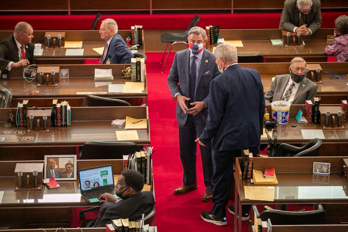 Senator Kirk deViere of Fayetteville talks with Rep. William Richardson of Fayetteville, N.C. on the House floor as they await Governor Roy Cooper’s arrival for the State of the State address on Monday, April 26, 2021 in Raleigh, N.C.