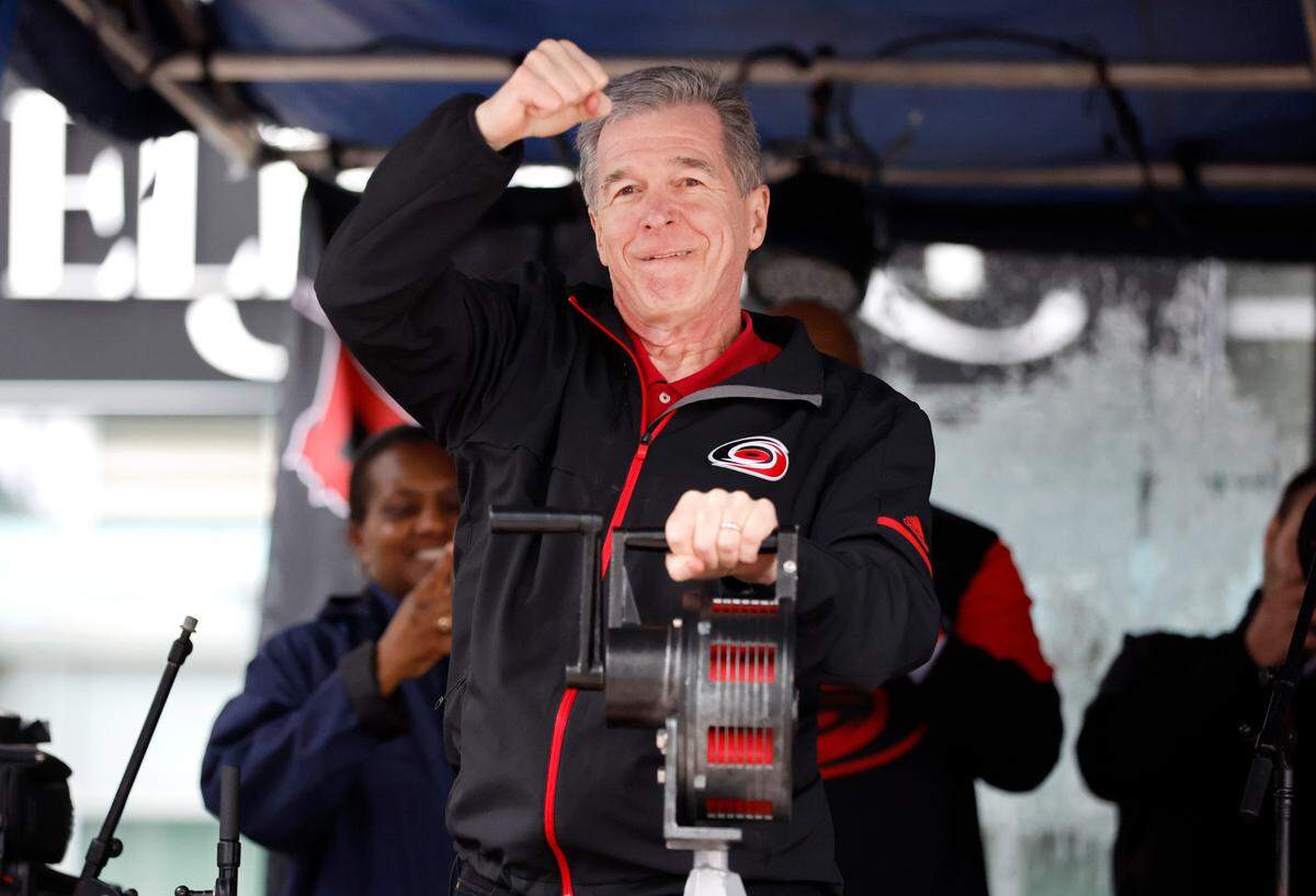 N.C. Gov. Roy Cooper celebrates after cranking the warning siren to kickoff the Carolina Hurricanes Fan Fest in downtown Raleigh on Feb. 17, 2023. The festival was part of the celebrations before the Carolina Hurricanes’ Stadium Series outdoor game against the Washington Capitals at Carter-Finley Stadium.