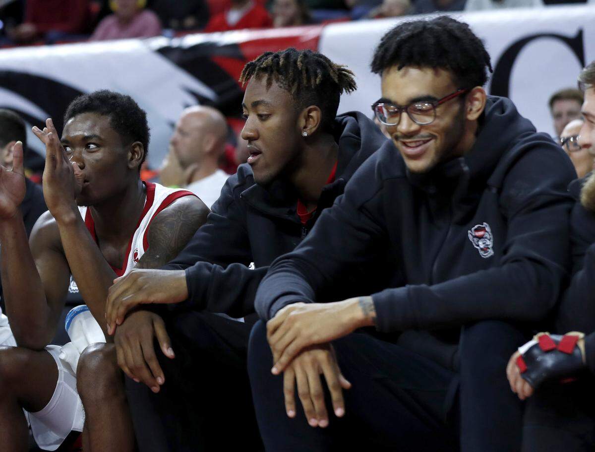N.C. State’s Manny Bates, center, and Sacha Killeya-Jones, right, watch during second half of N.C. State’s 111-62 exhibition victory over Chowan at PNC Arena in Raleigh, N.C., Monday, Oct. 29, 2018.