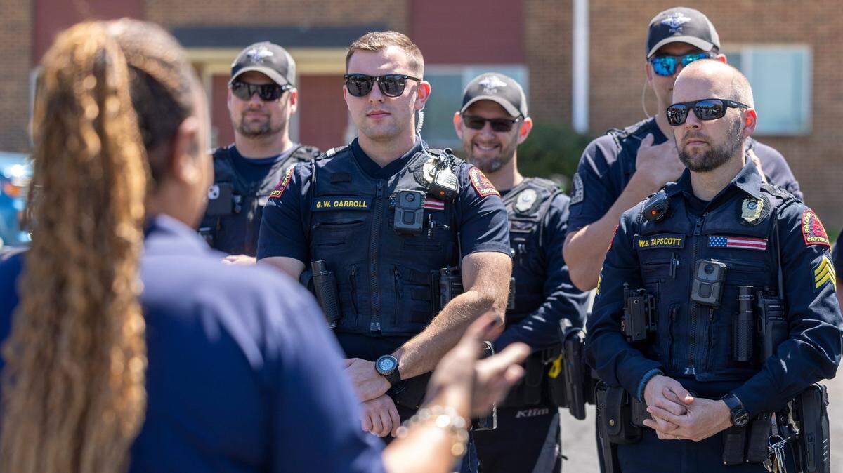 Raleigh Police Department officers listen to property manager Dawn Murphy at the Millbank Apartments in April. The officers were participating in a “Cops on the Block” initiative, which is working to strengthen relationships between police and city residents.