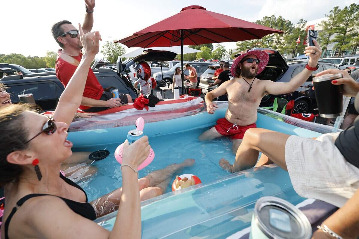 Gina Donati, left, and Chris Gagliano along with their friends and family cool down in a 10-foot by 6-foot pool in the back of a Ford F-250 while tailgating before the HurricanesÕ game against the Golden Knights in the fifth game of the Stanley Cup Final at the Lenovo Center in Raleigh, N.C., Thursday, June 11, 2026.
