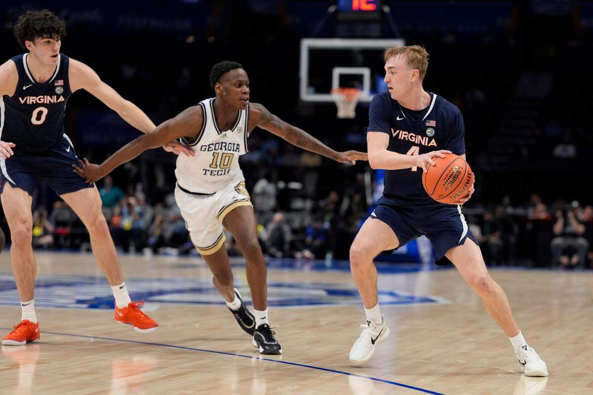 Virginia Cavaliers guard Andrew Rohde (4) handles the ball against Georgia Tech Yellow Jackets forward Darrion Sutton (10) during the first half at Spectrum Center.
