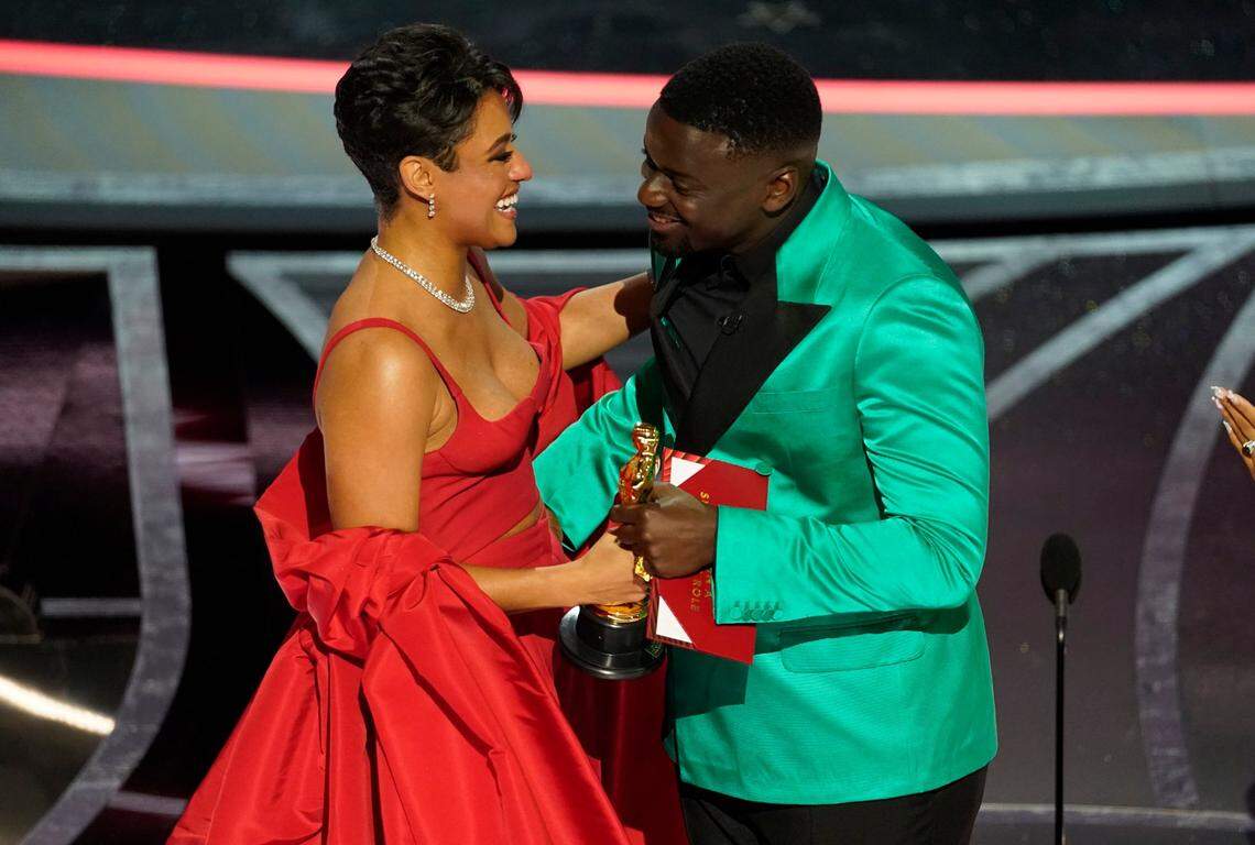 Ariana DeBose, left, accepts the award for best performance by an actress in a supporting role for “West Side Story” from Daniel Kaluuya at the Oscars on Sunday, March 27, 2022, at the Dolby Theatre in Los Angeles.