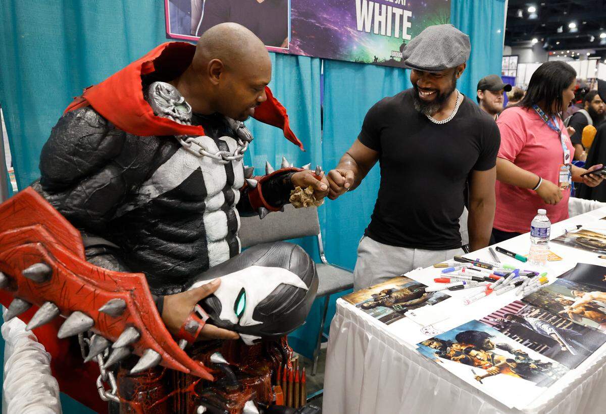 Michael Jai White fist bumps Mose Marshall from Efland after taking a photo with him Raleigh Convention Center during GalaxyCon on Saturday, July 27, 2024. Marshall is dressed as Spawn who White played in 1997.