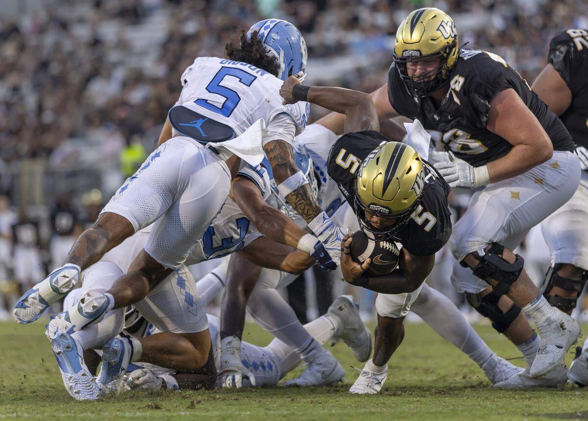 UCF running back Jaden Nixon (5) slips past North Carolina defensive back Gavin Gibson (5) on a five-yard run in the fourth quarter to secure the Golden Knights’ 34-9 victory over the Tar Heels on Saturday, September 20, 2025 at Acrisure Bounce House Stadium in Orlando, Fla.