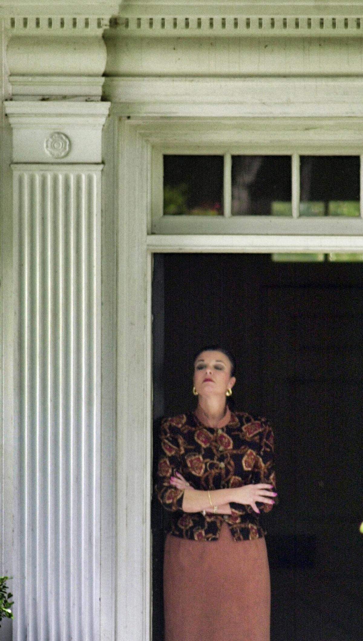 Durham prosecutor Freda Blackwatches jurors and other court officials from the front door of the Michael Peterson home in Durham Thursday afternoon during a planned jury visit to the home to view the staircase where Kathleen Peterson died.