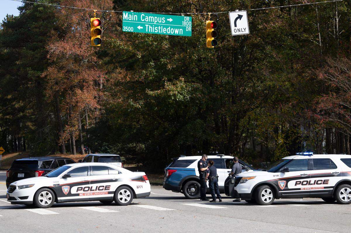 Law enforcement officers, including Raleigh and NC State police, gather at the scene on Trailwood Drive after shots were fired into a car Thursday near Interstate 40 and NC State’s Centennial Campus close to where Raleigh police were already investigating similar reports along the interstate this week. Two people were detained Thursday after 12 shootings into homes and cars.