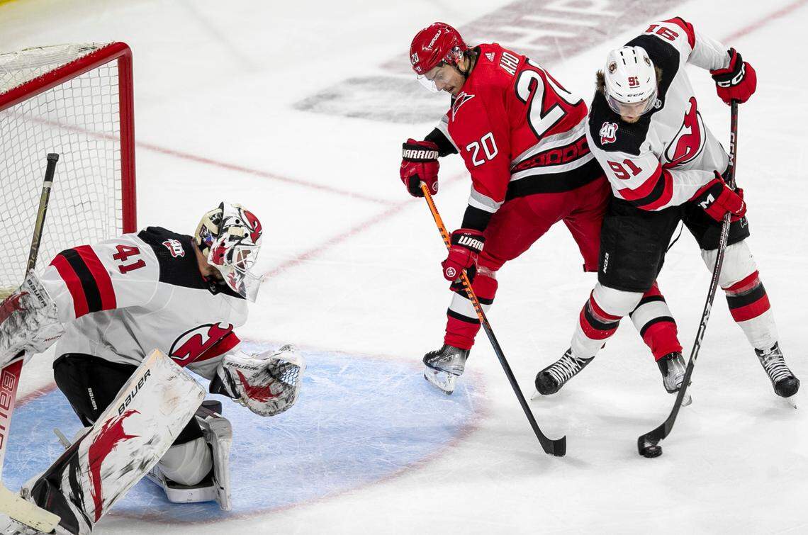 The New Jersey Devils Dawson Mercer (91) clears the puck, preventing a scoring attempt by the Carolina Hurricanes Sebastian Aho (20) in the third period during Game 2 of their second round Stanley Cup playoff series on Friday, May 5, 2023 at PNC Arena in Raleigh, N.C.