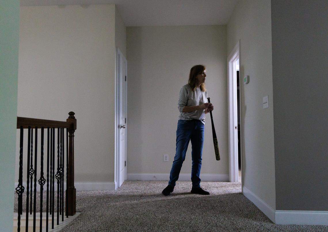 Jill Rohner carries a baseball bat while moving out of her former home on Wednesday, May 28, 2025, in Raleigh, N.C. Rohner’s partner was fatally shot by her ex-husband, against whom she had a domestic violence protective order, at the home in late January. 