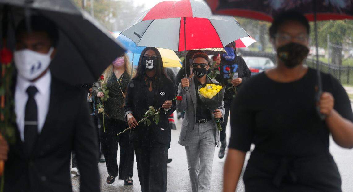 Heave Nahra, Miss St Augustine’s, left, and Aaliyah Williams, SGA president, march with other students and faculty down Oakwood Avenue to the home of St. Augustine’s University President Irving McPhail to pay their respects on Friday, October 16, 2020 in Raleigh, N.C. McPhail died yesterday from COVID-19.