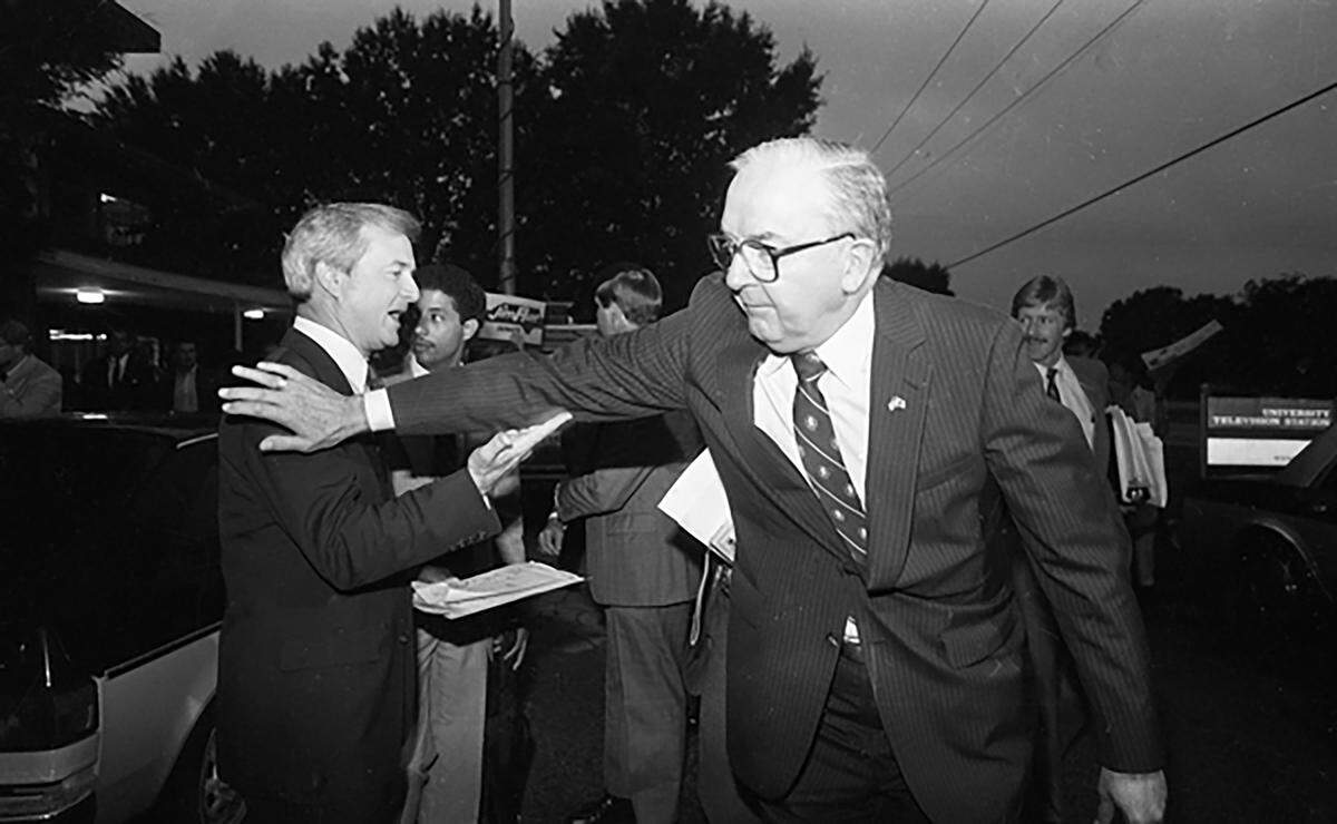Sen. Jesse Helms pats Jim Hunt after debating July 29, 1984.
