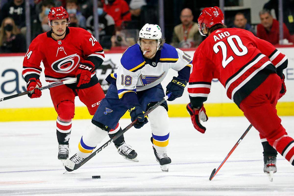 St. Louis Blues’ Robert Thomas (18) skates the puck between Carolina Hurricanes’ Seth Jarvis (24) and Sebastian Aho (20) during the first period of an NHL hockey game in Raleigh, N.C., Saturday, Nov. 13, 2021. (AP Photo/Karl B DeBlaker)
