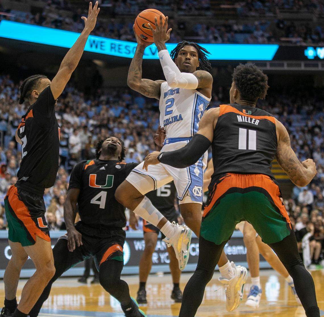 Miami’s Isaiah Wong (2), Bensely Joseph (4) and Jordan Miller (11) stop North Carolina’s Caleb Love (2) as he drives into the lane in the second half on Monday, February 13, 2023 at the Smith Center in Chapel Hill, N.C.