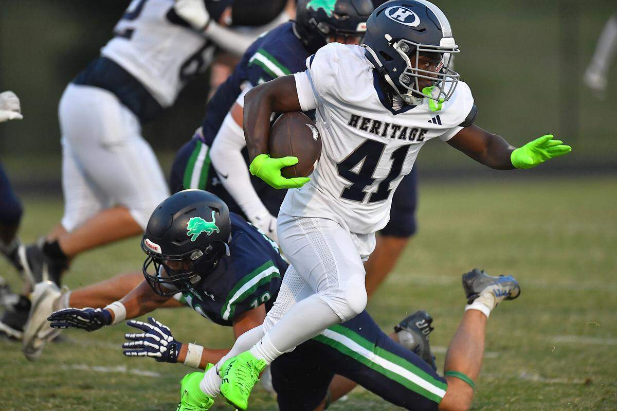 Heritage running back Brandon Hawkins (41) runs for yardage against Leesville Road's Adam Sonye (12) during the first half.  The Leesville Road Pride and the Heritage Huskies met in a  football game in Raleigh, N.C. on September 5, 2025.