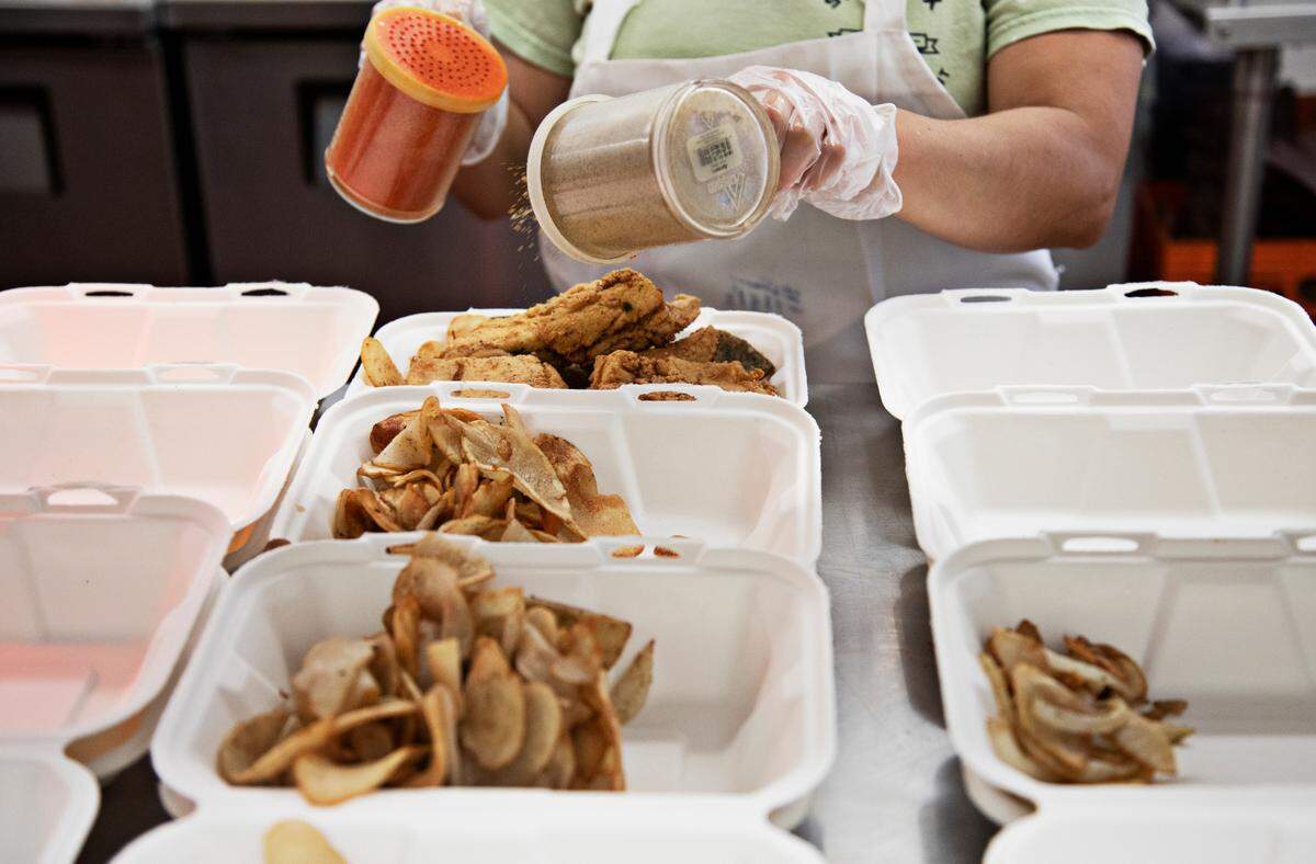 An employee at Saltbox Seafood Joint adds the finishing touches to orders on Wednesday June 15, 2022, during lunch service at the Durham restaurant. Owner and chef Ricky Moore received the award for Best Chef: Southeast on Monday night in Chicago at the James Beard Foundation’s Awards.