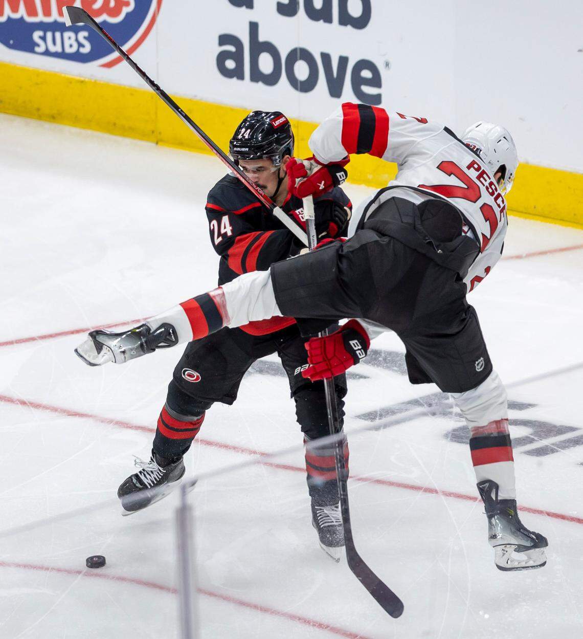 Carolina Hurricanes center Seth Jarvis (24) checks New Jersey Devils defenseman Brett Pesce (22) in the second period on Sunday, April 20, 2025 at Lenovo Center in Raleigh, N.C.
