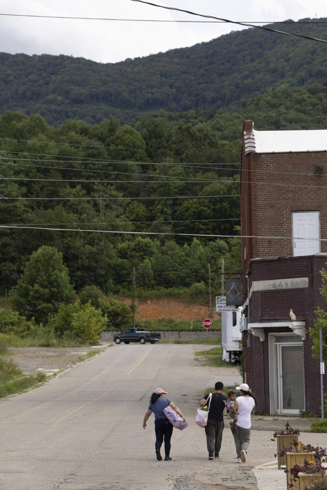 Swannanoa residents carry food from a giveaway organized by the Bounty & Soul Free Produce Market at the former Swannanoa United Methodist Church on Aug. 13.