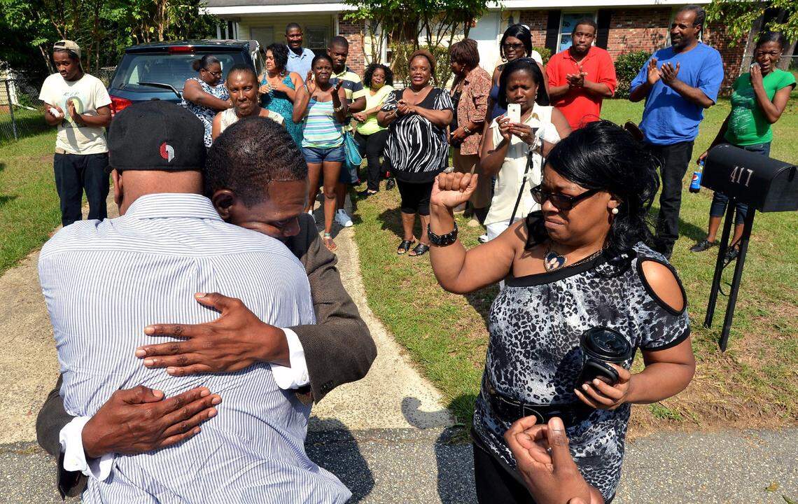 Geraldine Brown (right) fights back tears as her brothers Leon Brown (left)) and Henry McCollum greet each other in the front yard of her Fayetteville, N.C. home Wednesday, Sept. 3, 2014. In the background friends and relatives applaud. The brothers were released from prison Wednesday after their rape and murder conviction was dismissed by a Robeson County Superior Court judge on Tuesday. The brothers spent 30 years in prison for a crime they didn’t commit.