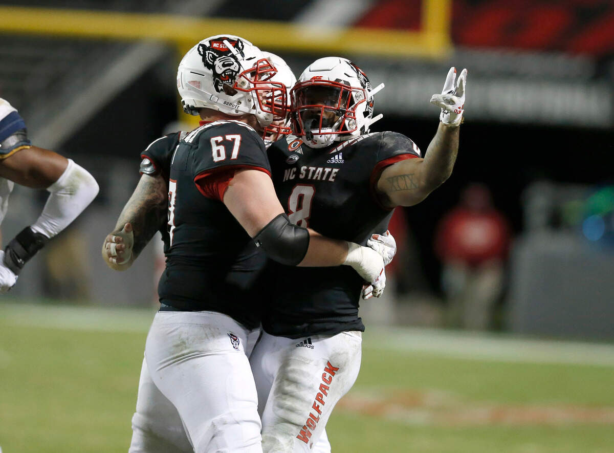 N.C. State offensive tackle Justin Witt (67) celebrates with running back Ricky Person Jr. (8) after Person ran for a first down during the second half of N.C. State’s 23-13 victory over Georgia Tech at Carter-Finley Stadium in Raleigh, N.C., Saturday, Dec. 5, 2020.