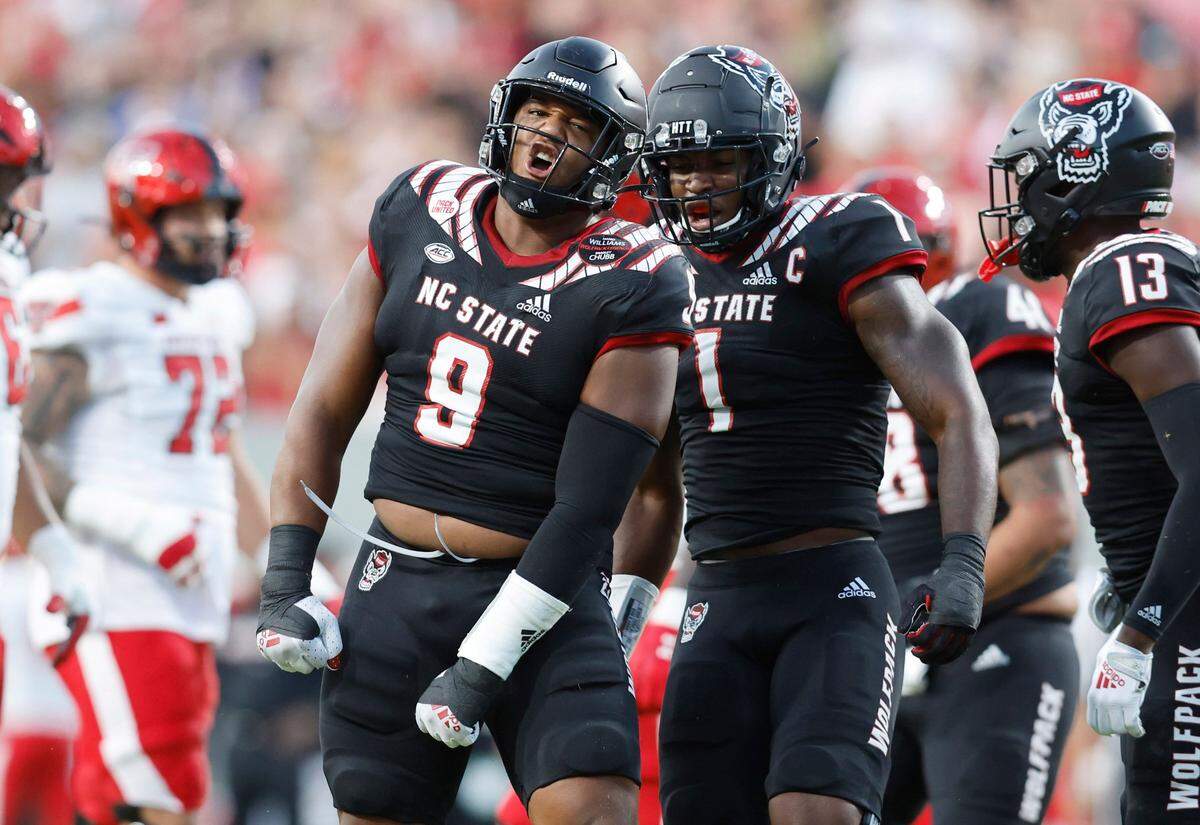 N.C. States Isaiah Moore (1) celebrates with Savion Jackson (9) after Jackson stopped Texas Tech running back Tahj Brooks (28) for a loss during the first half of N.C. States game against Texas Tech at Carter-Finley Stadium in Raleigh, N.C., Saturday, Sept. 17, 2022.