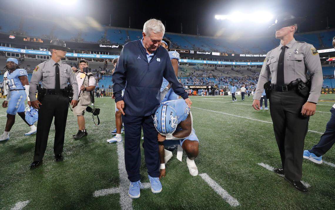 North Carolina head coach Mack Brown checks on running back British Brooks (24), who was brought to tears after UNC’s 31-17 victory over South Carolina in the Duke’s Mayo Classic at Bank of America Stadium in Charlotte, N.C., Saturday, Sept. 2, 2023.