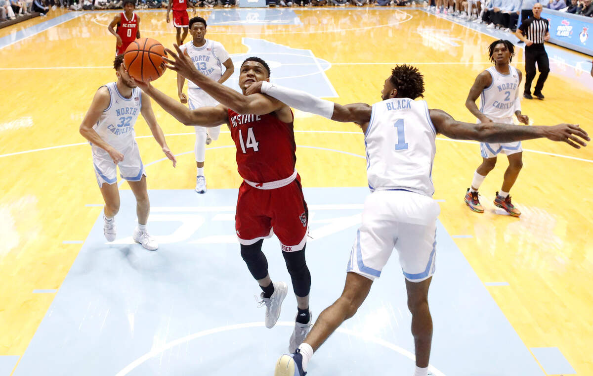 North Carolina’s Leaky Black (1) fouls N.C. State’s Casey Morsell (14) as he shoots during UNC’s 80-69 victory over N.C. State at the Smith Center in Chapel Hill, N.C., Saturday, Jan. 21, 2023.