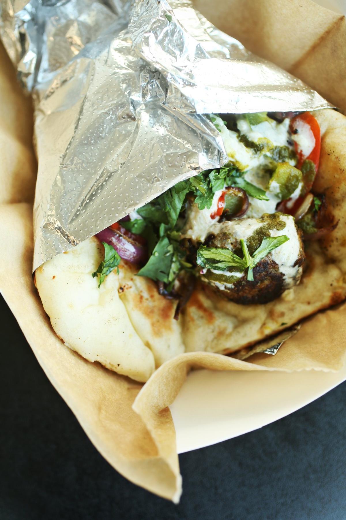 The Naanwich, an Indian-style wrap made by folding naan around your choice of protein with sauteed onions and peppers, and topped with raita and cilantro chutney, is a unique menu offering at Curry in a Hurry.
